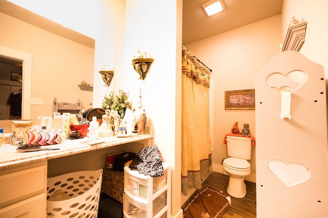 bathroom with wood-type flooring, toilet, vanity, and a shower with curtain