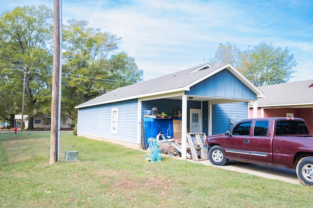 view of front of home with a front yard and a carport