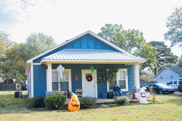 bungalow featuring a front yard, central AC, and covered porch