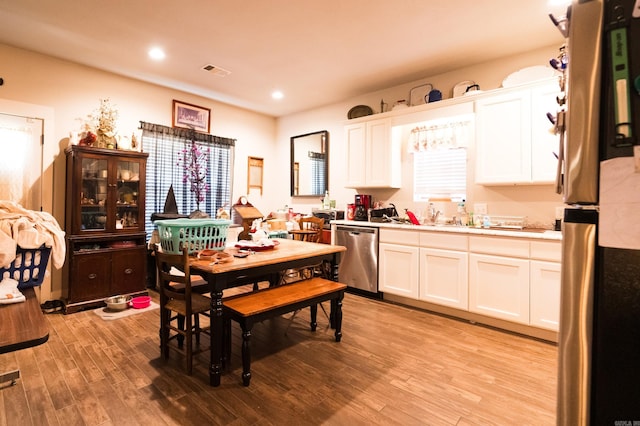 kitchen featuring white cabinets, light hardwood / wood-style floors, plenty of natural light, and appliances with stainless steel finishes