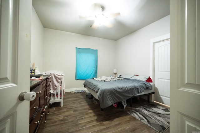 bedroom with dark hardwood / wood-style floors and ceiling fan