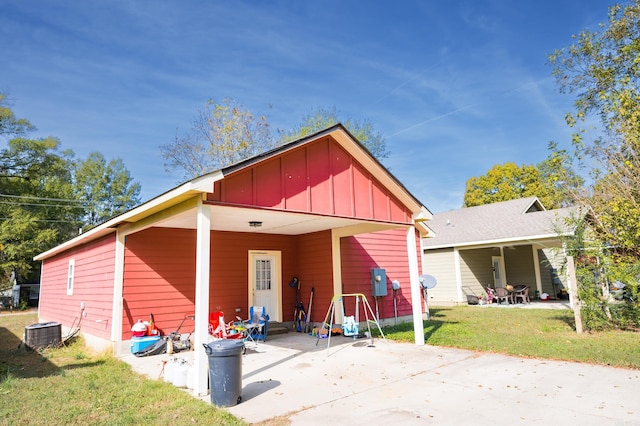 back of house featuring central AC unit and a yard