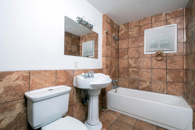 bathroom featuring tile walls, tile patterned flooring, and toilet