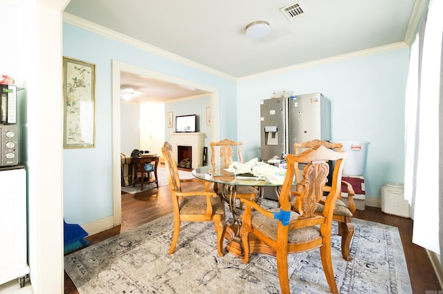 dining room featuring dark hardwood / wood-style flooring and ornamental molding