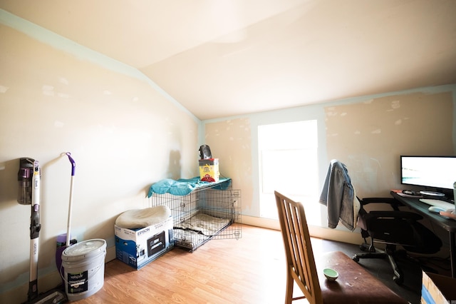 home office featuring light hardwood / wood-style floors and vaulted ceiling