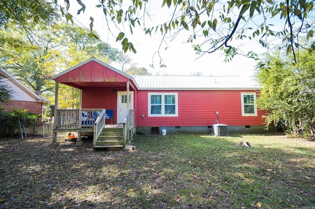 rear view of property with central air condition unit, a lawn, and a deck