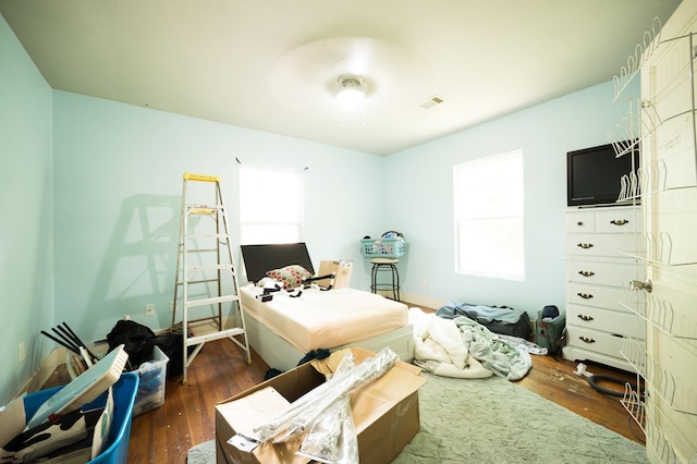 bedroom with dark hardwood / wood-style flooring and ceiling fan