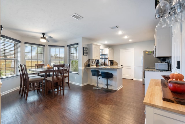 dining space with ceiling fan and dark hardwood / wood-style floors