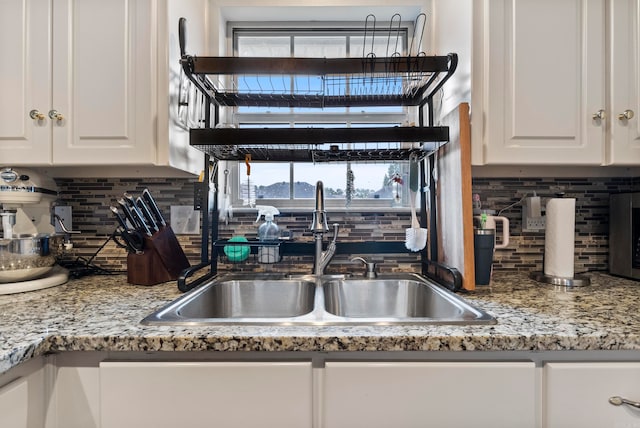 kitchen with decorative backsplash, sink, a healthy amount of sunlight, and white cabinets