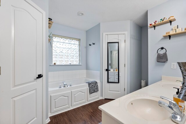 bathroom with a bathing tub, wood-type flooring, and vanity