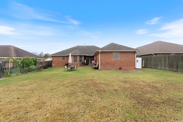 rear view of property with a yard