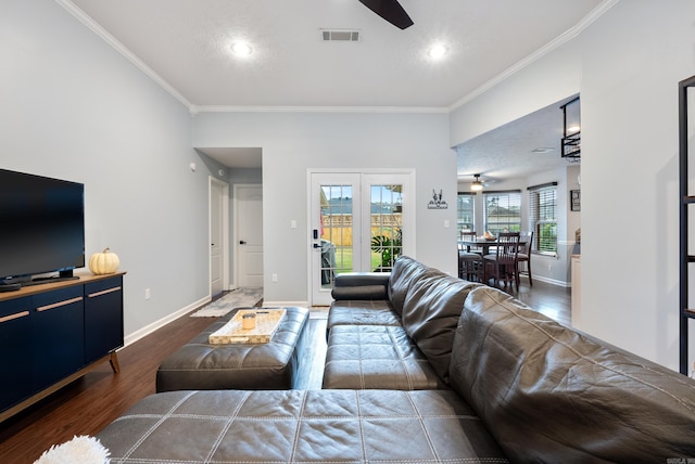 living room with dark wood-type flooring, ceiling fan, and crown molding