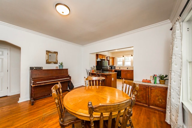 dining space with hardwood / wood-style flooring and crown molding