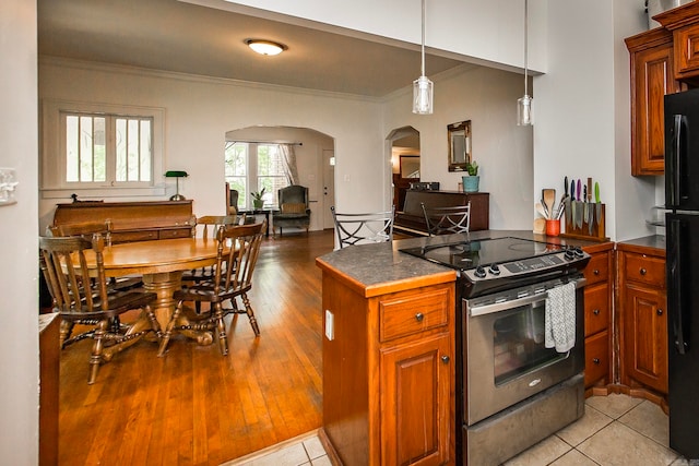 kitchen with light wood-type flooring, hanging light fixtures, black appliances, and crown molding