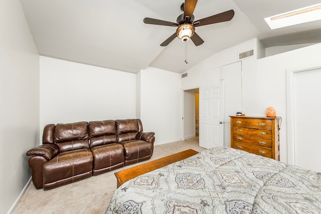 carpeted bedroom with vaulted ceiling with skylight and ceiling fan