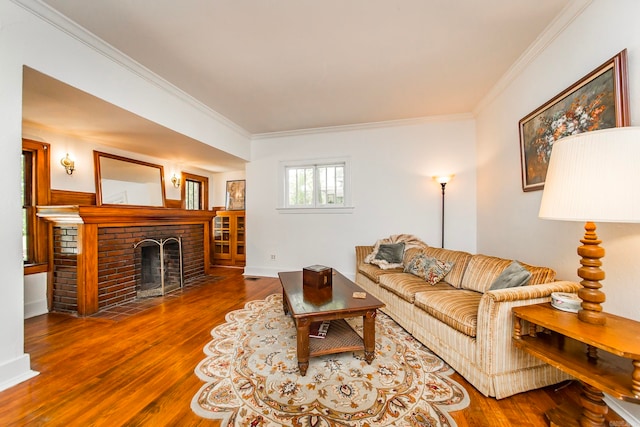 living room featuring hardwood / wood-style floors, ornamental molding, and a brick fireplace