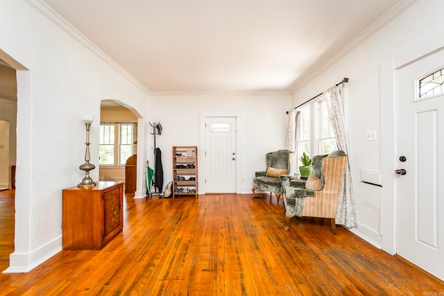 entryway featuring a healthy amount of sunlight, dark hardwood / wood-style floors, and crown molding