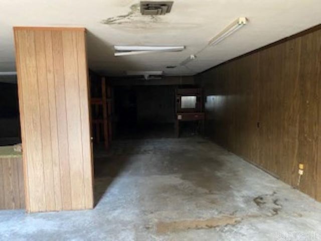 interior space featuring wood walls and concrete floors