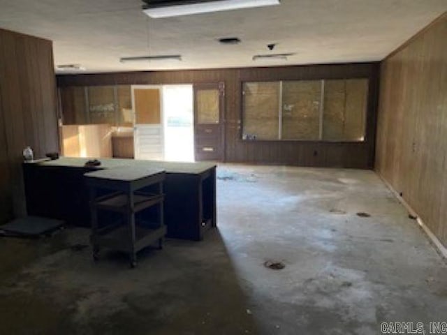 interior space featuring wooden walls and concrete floors