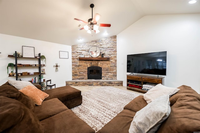 living room featuring ceiling fan, a stone fireplace, and vaulted ceiling