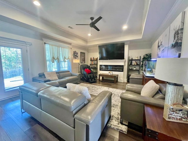 living room featuring crown molding, dark hardwood / wood-style floors, ceiling fan, and a tray ceiling