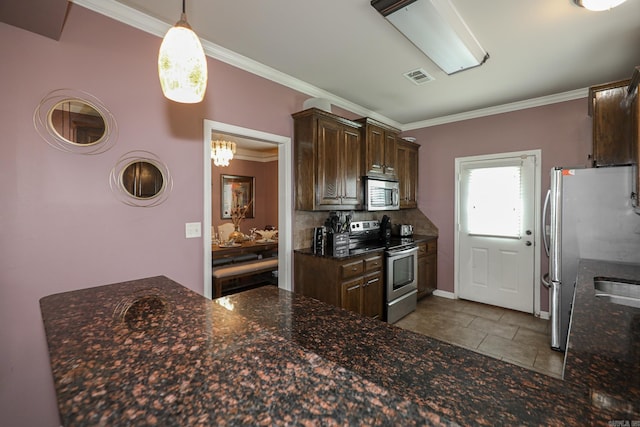 kitchen featuring pendant lighting, crown molding, and stainless steel appliances