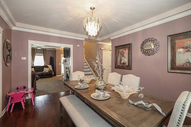 dining area featuring dark hardwood / wood-style floors, a chandelier, and ornamental molding