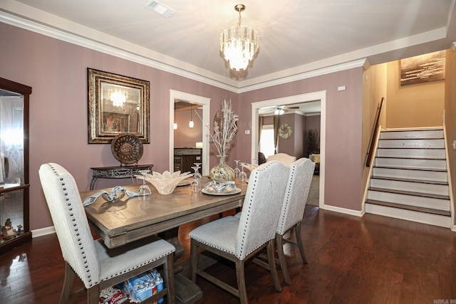 dining room with ornamental molding, ceiling fan with notable chandelier, and dark hardwood / wood-style flooring