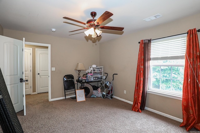 carpeted office featuring ceiling fan