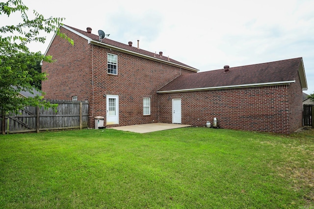 back of property with a patio area and a lawn