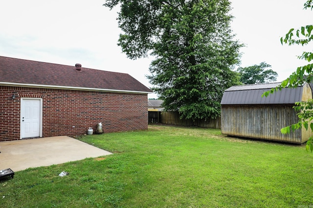 view of yard featuring a shed and a patio area