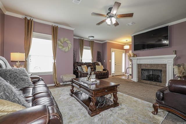 living room with ornamental molding, a wealth of natural light, ceiling fan, and a tile fireplace