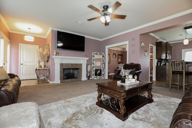 carpeted living room with ceiling fan, a tile fireplace, a healthy amount of sunlight, and ornamental molding