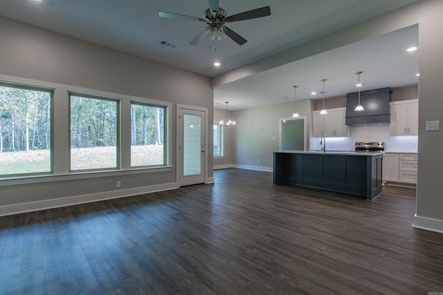 unfurnished living room featuring dark wood-type flooring, sink, and ceiling fan with notable chandelier