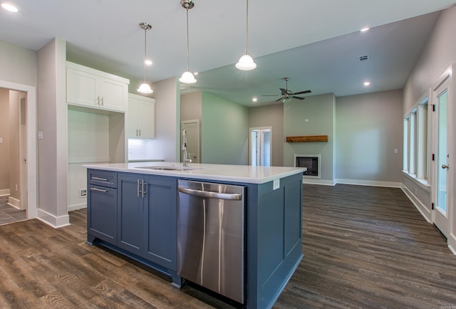 kitchen with a center island with sink, a large fireplace, decorative light fixtures, stainless steel dishwasher, and white cabinets