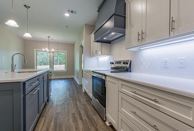 kitchen featuring dark hardwood / wood-style flooring, hanging light fixtures, sink, appliances with stainless steel finishes, and premium range hood