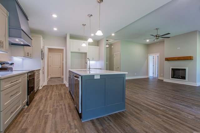 kitchen with stainless steel appliances, dark hardwood / wood-style floors, white cabinetry, and an island with sink