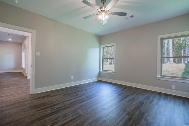 unfurnished room featuring dark wood-type flooring, ceiling fan, and plenty of natural light