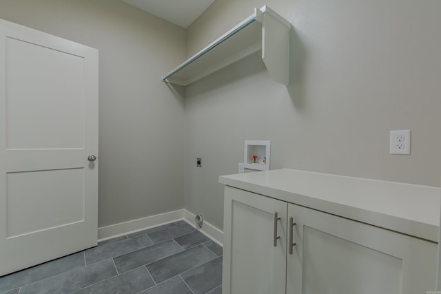 laundry room with hookup for an electric dryer, washer hookup, and dark tile patterned flooring