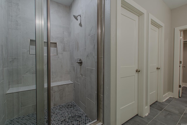 bathroom featuring a shower with shower door and tile patterned floors