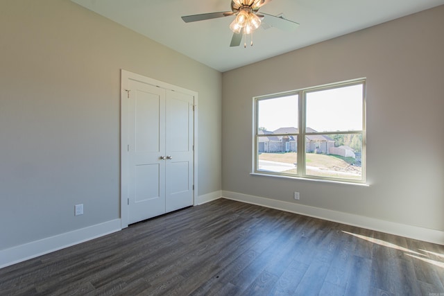 unfurnished bedroom with a closet, ceiling fan, and dark hardwood / wood-style floors