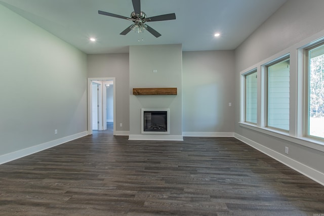 unfurnished living room with ceiling fan, a healthy amount of sunlight, and dark hardwood / wood-style flooring