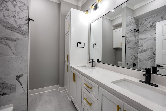 bathroom with toilet, vanity, and ornamental molding