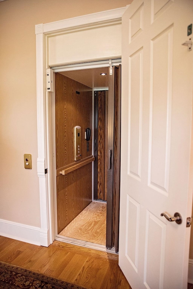 hallway featuring elevator and hardwood / wood-style floors