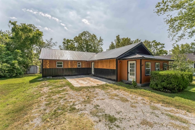 rear view of house featuring a shed, a lawn, and a patio area