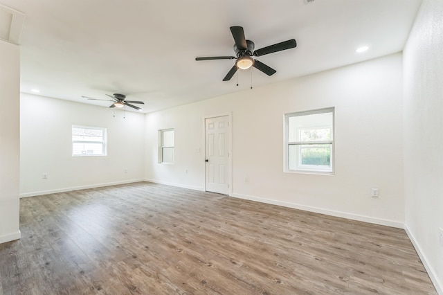 empty room featuring light wood-type flooring, plenty of natural light, and ceiling fan