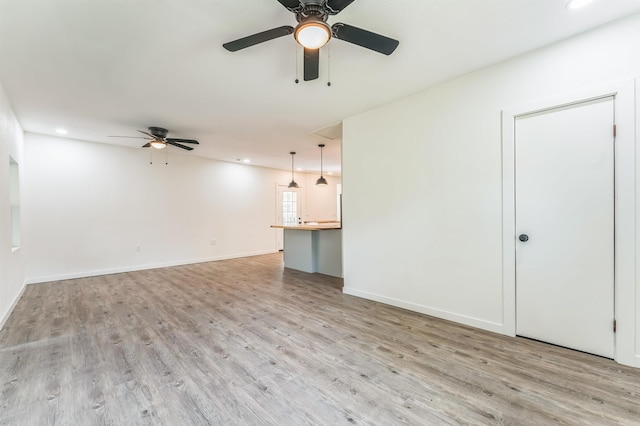 unfurnished living room with ceiling fan and light hardwood / wood-style flooring