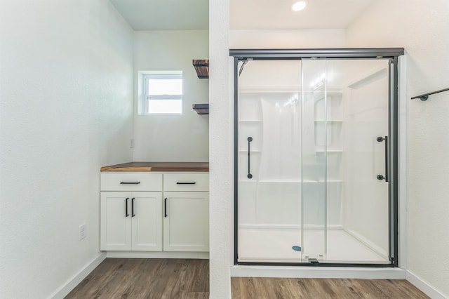 bathroom featuring wood-type flooring, vanity, and an enclosed shower