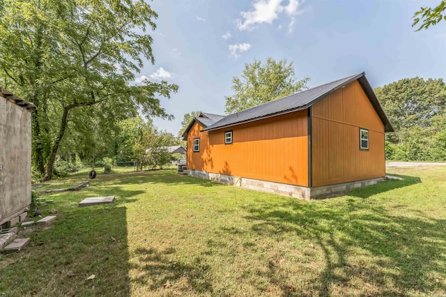 view of side of home featuring an outdoor structure and a lawn