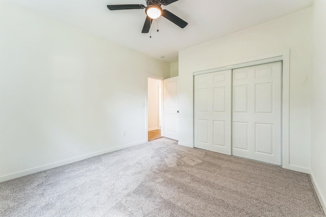 unfurnished bedroom with ceiling fan, a closet, and light colored carpet